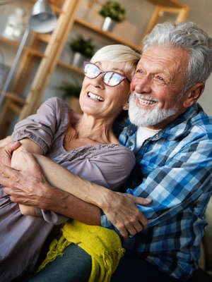 Happy romantic mature couple hugging and enjoying retirement at home